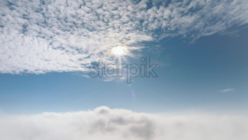 Video - Aerial drone view of the sky with clouds and bright sun