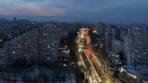 Video - Aerial drone view of the Сity Gates with multiple buildings and moving traffic in the evening, blue hour. Winter in Chisinau, Moldova