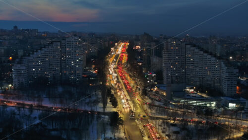 Video - Aerial drone view of the Сity Gates with multiple buildings and moving traffic in the evening, blue hour. Winter in Chisinau, Moldova