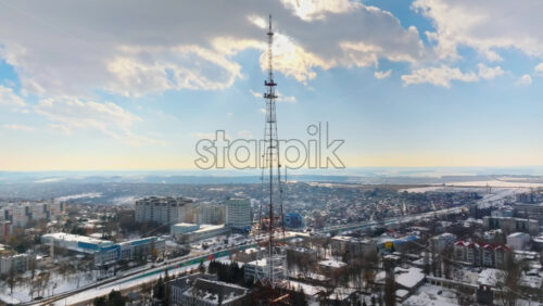 Video - Aerial drone view of the radio transmission tower in the daylight. Ground covered in snow in Chisinau, Moldova