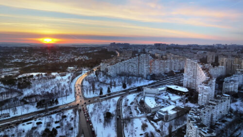 Video - Aerial drone view of the City Gates with multiple buildings and moving traffic during sunset. Winter in Chisinau, Moldova