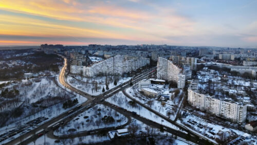Video - Aerial drone view of the City Gates with multiple buildings and moving traffic during sunset. Winter in Chisinau, Moldova