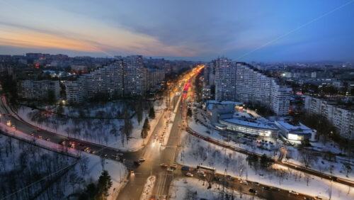 Video - Aerial drone view of the Сity Gates with multiple buildings and moving traffic in the evening, blue hour. Winter in Chisinau, Moldova