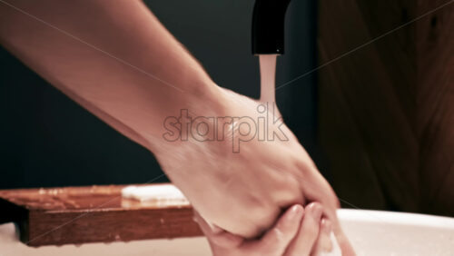 Video - A man carefully washing his hands with a soap in the bathroom