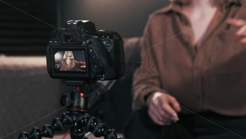 Video - Young content creator blonde girl putting a camera on a tripod and filming herself talking for vlog. Working from home