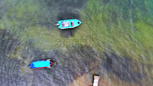 Video - Aerial drone view of two moored boats in transparent water of the Aegean sea. Greece