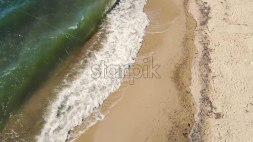 Video - Aerial drone view of the Aegean sea coast in Nikiti, Greece. Beach with waves of the sea, top view