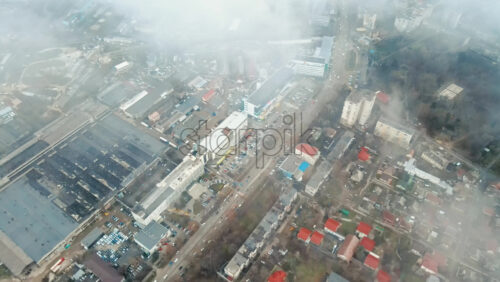 Video - Aerial drone view of Chisinau through the clouds. Panorama view of multiple buildings, roads with moving cars and bare trees. Moldova