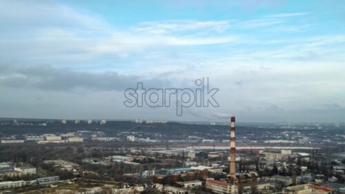 Video - Aerial drone view of Chisinau. Thermal station with smoke coming out of the tube. Buildings, roads and bare trees. Cloudy weather. Moldova