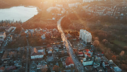 Video - Aerial drone view of Chisinau. View of multiple buildings, roads and bare trees, park and a lake. Good weather with setting sun. Moldova