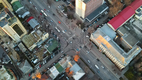 Video - Aerial drone view of Chisinau at sunset. View of multiple buildings, street with moving cars, bare trees. Moldova