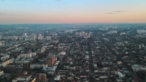 Video - Aerial drone view of Chisinau. Panorama view of multiple buildings, roads with moving cars, bare trees. Moldova