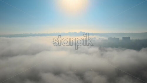 Video - Aerial drone view above the clouds with buildings visible through, Chisinau, Moldova
