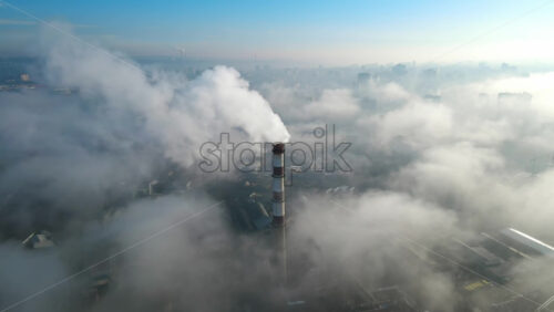 Video - Aerial drone view of Chisinau. Thermal station with smoke coming out of the tube. Buildings, roads. Low clouds. Moldova