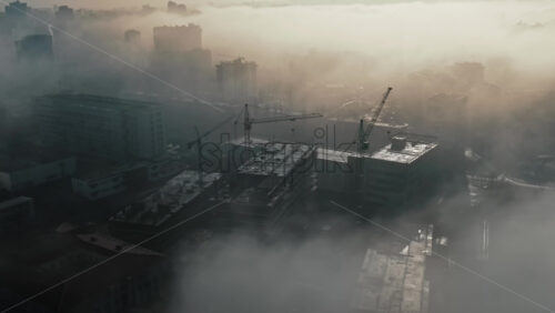 Video - Aerial drone view above the clouds with buildings and construction works visible through, Chisinau, Moldova
