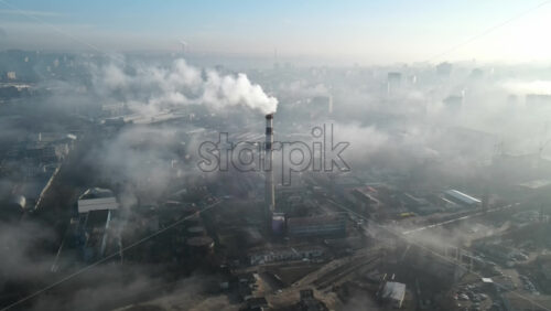 Video - Aerial drone view of Chisinau. Thermal station with smoke coming out of the tube. Buildings, roads. Fog in the air. Moldova