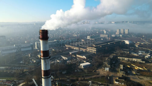Video - Aerial drone view of Chisinau. Thermal station with smoke coming out of the tube. Buildings, roads. Fog in the air. Moldova