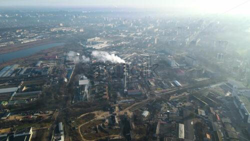 Video - Aerial drone view of Chisinau. Thermal station with smoke coming out of the tube. Buildings, roads, lake. Fog in the air. Moldova