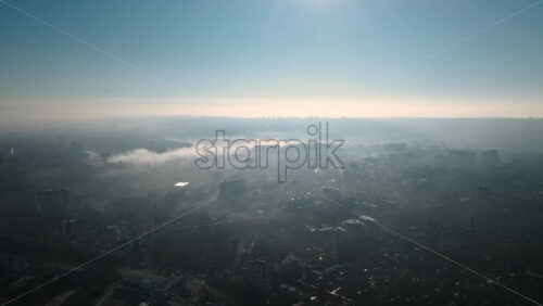 Video - Aerial drone view of Chisinau. Panorama view of multiple buildings, roads and bare trees. Good weather with fog in the air and low clouds. Moldova