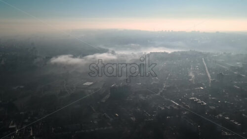 Video - Aerial drone view of Chisinau. Panorama view of multiple buildings, roads and bare trees. Good weather with fog in the air and low clouds. Moldova
