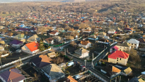 Video - Aerial drone view of a village. View of multiple residential buildings, country roads, bare trees. Sunny weather. Moldova