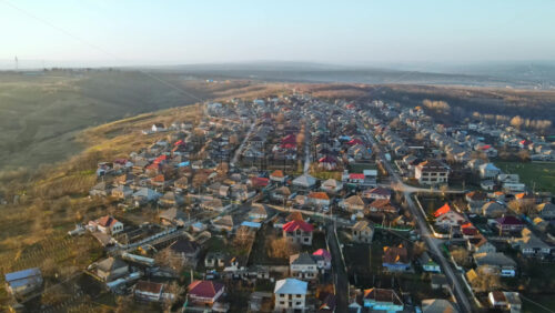 Video - Aerial drone view of a village. View of multiple residential buildings, country roads, bare trees. Sunny weather. Moldova