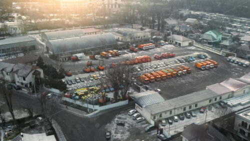 Video - Aerial drone view of industrial zone in Chisinau, Moldova. Multiple parked garbage trucks, hangars, Cloudy weather, bare trees, winter