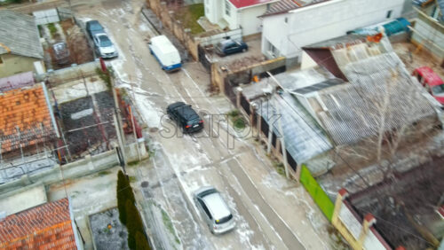 Video - Aerial drone view of a residential distict in Chisinau, Moldova. Multiple buildings, road, moving car, Cloudy weather, bare trees, winter