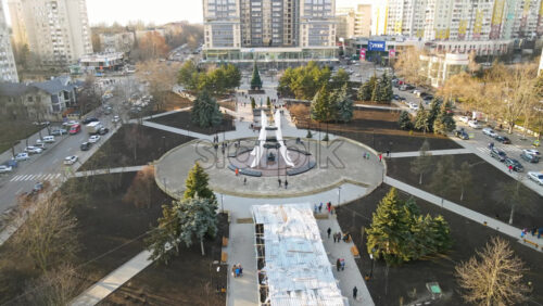 Video - CHISINAU, MOLDOVA - JANUARY 15, 2021: Aerial drone view of a Afghan memorial park in Chisinau, Moldova. Walking people, roads with cars, memorial, trees and buildings. Winter