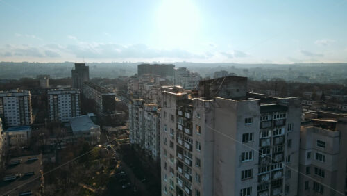 Video - CHISINAU, MOLDOVA - JANUARY 15, 2021: Aerial drone view of city. Multiple residential buildings, road with moving cars. Bare trees, winter