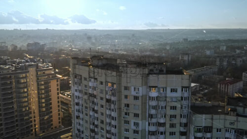 Video - Aerial drone view of Chisinau, Moldova at sunset. Residential soviet building, cityscape on the background. Bare trees, winter