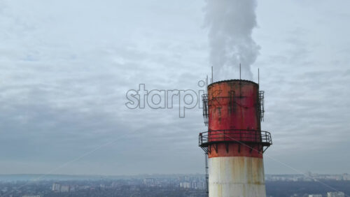 Video - Aerial drone view of Chisinau. Tube of the thermal station with smoke coming out. Cityscape on the background. Cloudy weather. Moldova