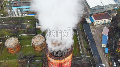 Video - Aerial drone view of Chisinau. Tube of the thermal station with smoke coming out. Industrial zone near it. Cloudy weather. Moldova