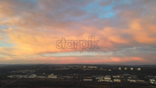 Video - Aerial drone view of Chisinau at sunset. Panorama view of buildings, bare trees, hills. Rose clouds. Moldova