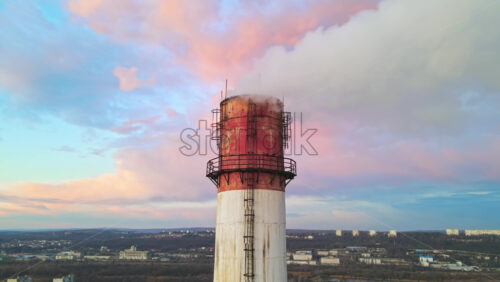 Video - Aerial drone view of Chisinau at sunset. Tube of the thermal station with smoke coming out. Cityscape on the background. Moldova