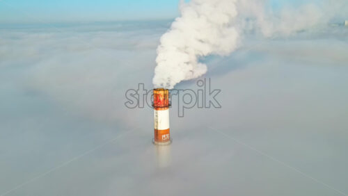 Video - Aerial drone view of Chisinau. Tube of the thermal station with smoke coming out above the low clouds. Visible buildings. Moldova