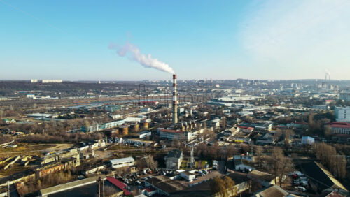 Video - Aerial drone view of Chisinau. Thermal station with smoke coming out of the tube. Buildings, roads and bare trees. Good weather. Moldova