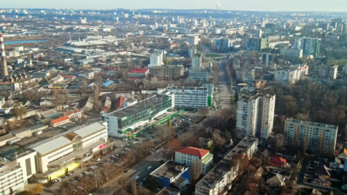 Video - Aerial drone view of Chisinau. Panorama view of multiple buildings, roads with moving cars and bare trees. Good weather with fog in the air. Moldova