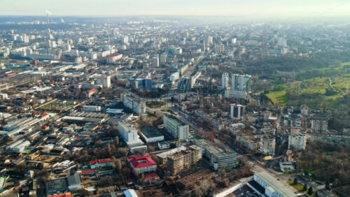 Video - Aerial drone view of Chisinau. Panorama view of multiple buildings, roads with moving cars and bare trees. Good weather. Moldova