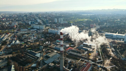 Video - Aerial drone view of Chisinau. Thermal station with smoke coming out of the tube. Buildings, roads and bare trees. Good weather. Moldova