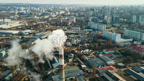 Video - Aerial drone hyperlapse view of Chisinau. Thermal station with smoke coming out of the tube. Buildings, roads and bare trees. Good weather. Moldova