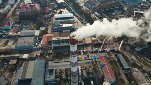 Video - Aerial drone view of Chisinau. Thermal station with smoke coming out of the tube. Buildings, roads and bare trees. Good weather. Moldova