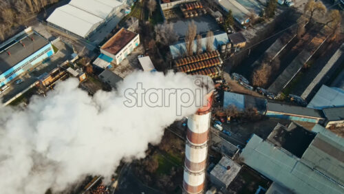 Video - Aerial drone view of Chisinau. Thermal station with smoke coming out of the tube. Buildings, roads and bare trees. Good weather. Moldova