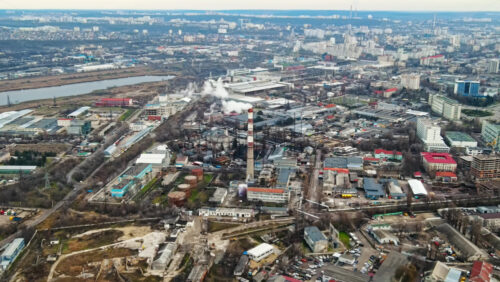 Video - Aerial drone view of Chisinau. Panorama view of multiple buildings, thermal station, roads with moving cars and bare trees. Moldova