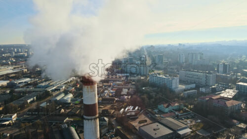 Video - Aerial drone view of Chisinau. Thermal station with smoke coming out of the tube. Buildings, roads and bare trees. Good weather. Moldova