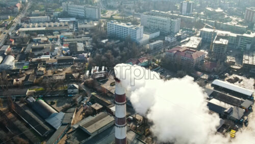 Video - Aerial drone view of Chisinau. Thermal station with smoke coming out of the tube. Buildings, roads and bare trees. Good weather. Moldova