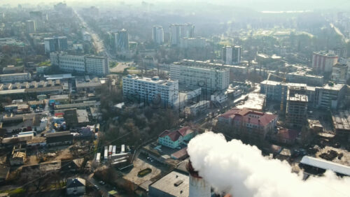 Video - Aerial drone view of Chisinau. Thermal station with smoke coming out of the tube. Buildings, roads and bare trees. Good weather. Moldova