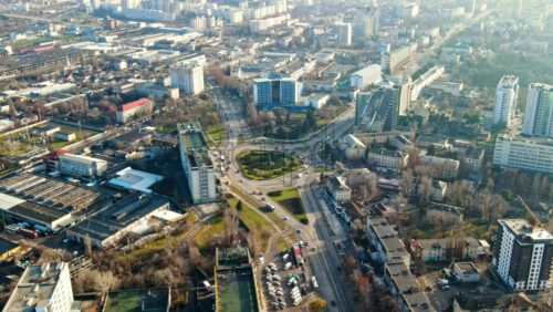 Video - Aerial drone view of Chisinau. Panorama view of multiple buildings, roads with moving cars and bare trees. Good weather with fog in the air. Moldova