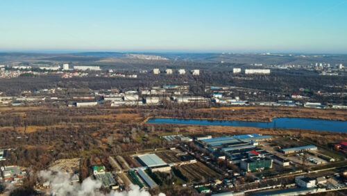 Video - Aerial drone view of Chisinau. Thermal station with smoke coming out of the tube. Buildings, roads and bare trees. View over the hills. Good weather. Moldova