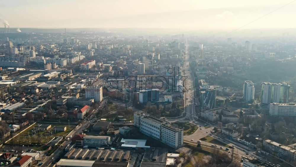 Video - Aerial drone view of Chisinau. Panorama view of multiple buildings, roads with moving cars and bare trees. Good weather with fog in the air. Moldova